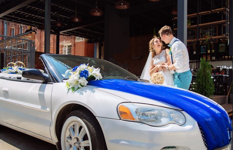 bride groom are photographed near car